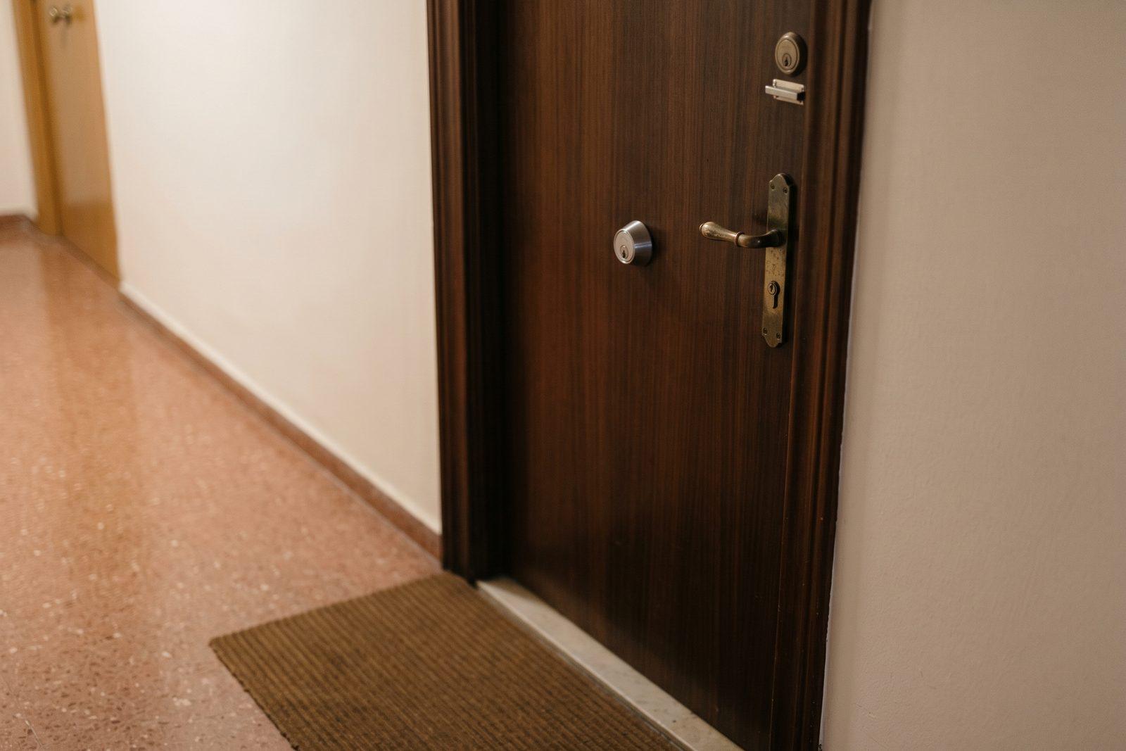 Puerta de entrada de un piso en un rellano con suelo de terrazo