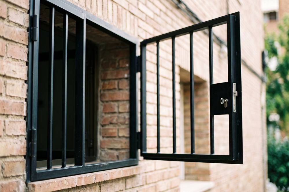 Reja abatible abierta en una ventana de planta baja